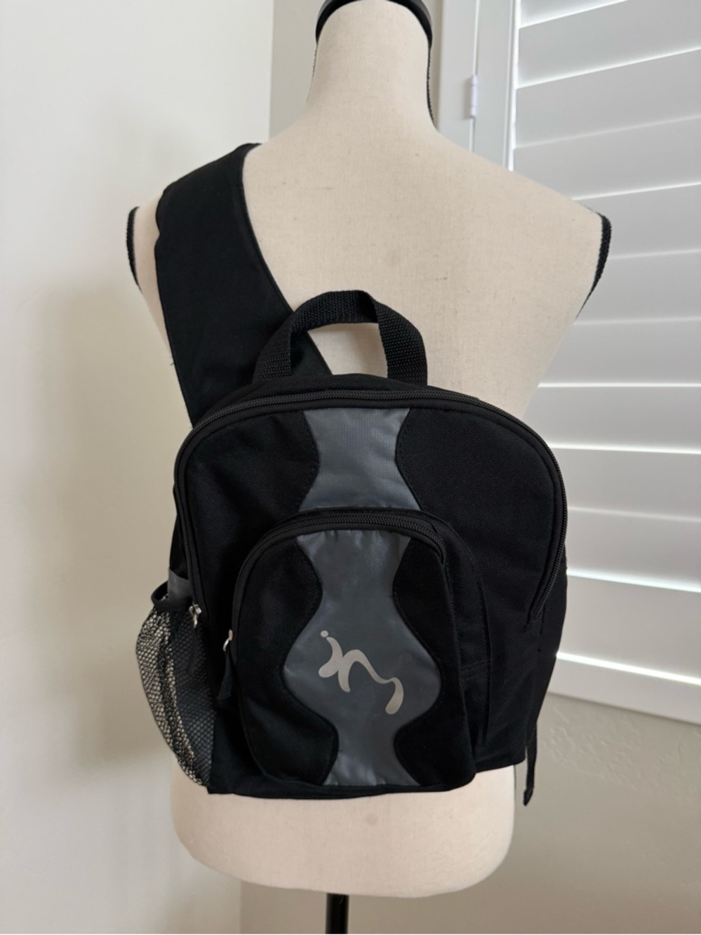 Black Sling Backpack with Two Zip Pockets.